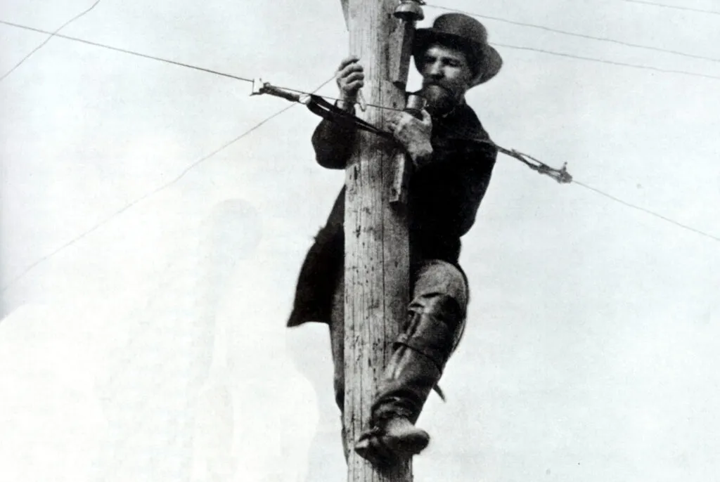 Photo from Northwest Lineman College of a lineman wearing climbers during the Civil War telegraph.